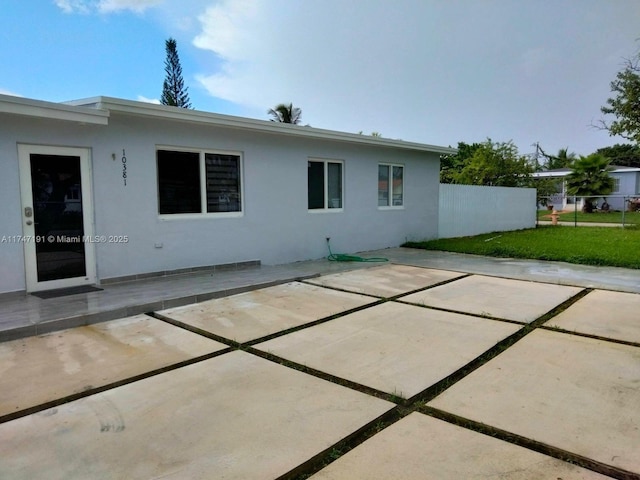 back of property featuring a patio area, fence, and stucco siding