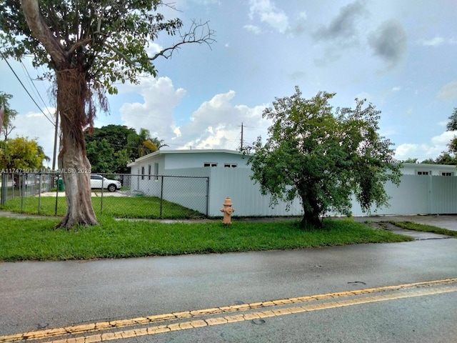 view of side of home with fence and a yard