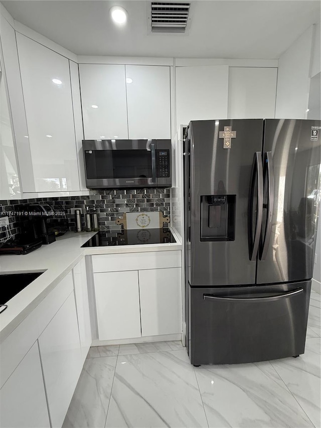 kitchen featuring visible vents, decorative backsplash, appliances with stainless steel finishes, marble finish floor, and white cabinetry