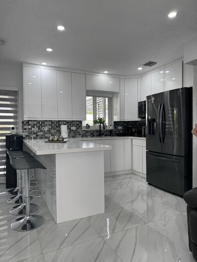 kitchen with light countertops, white cabinets, black appliances, and modern cabinets