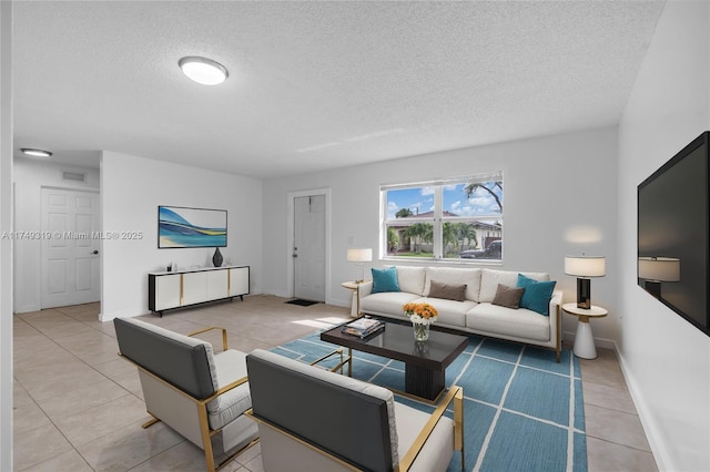 living room featuring visible vents, a textured ceiling, baseboards, and tile patterned floors