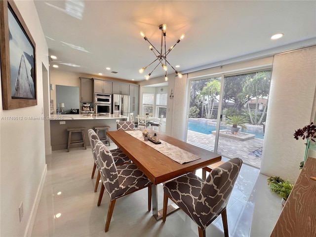 dining space with a chandelier, recessed lighting, and baseboards