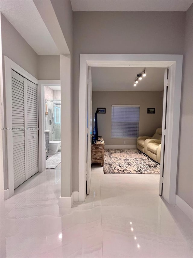 hall with marble finish floor and baseboards