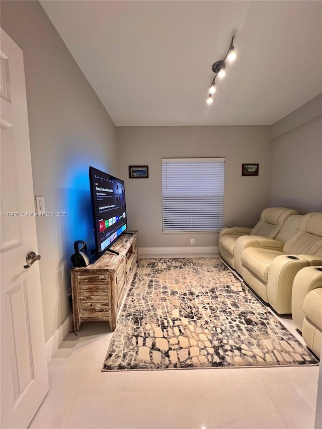 living area with rail lighting and baseboards