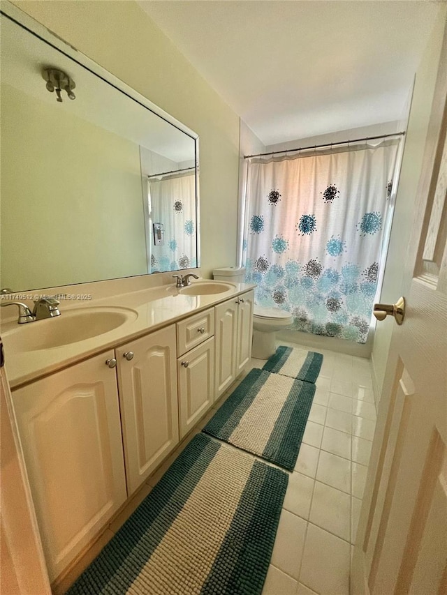 full bathroom with double vanity, toilet, a sink, and tile patterned floors