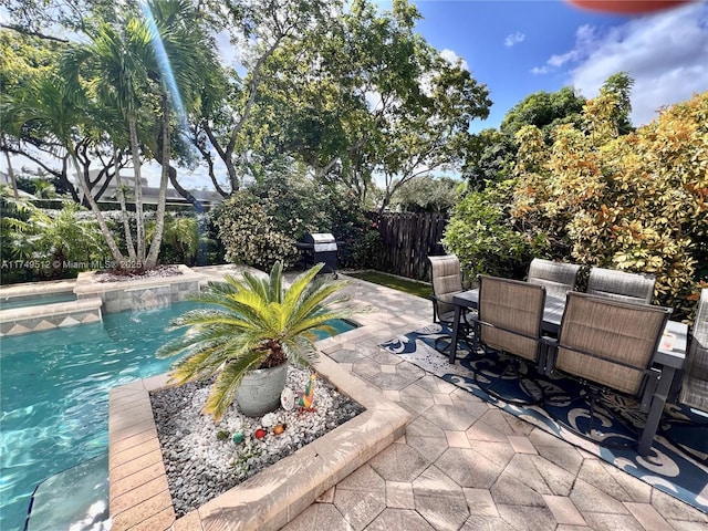 view of patio with outdoor dining space, a fenced backyard, and a fenced in pool