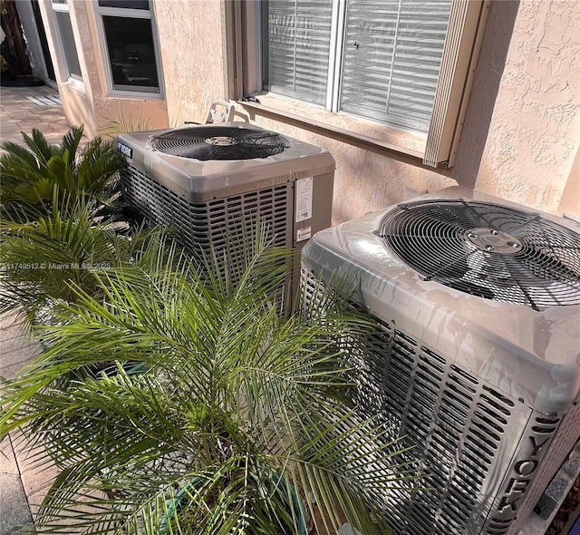 exterior details with central AC unit and stucco siding