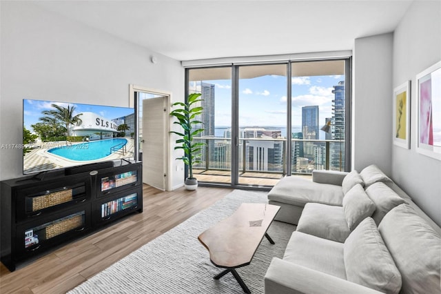 living room with light wood-type flooring, expansive windows, and a city view