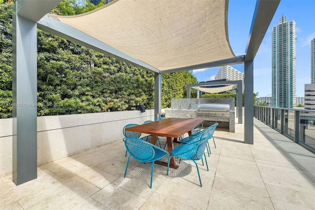 view of patio featuring exterior kitchen, a view of city, outdoor dining space, and area for grilling