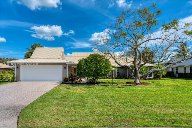 single story home with metal roof, a front lawn, decorative driveway, and an attached garage