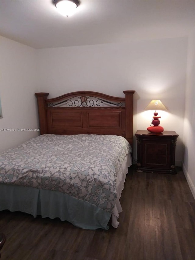 bedroom with dark wood-type flooring