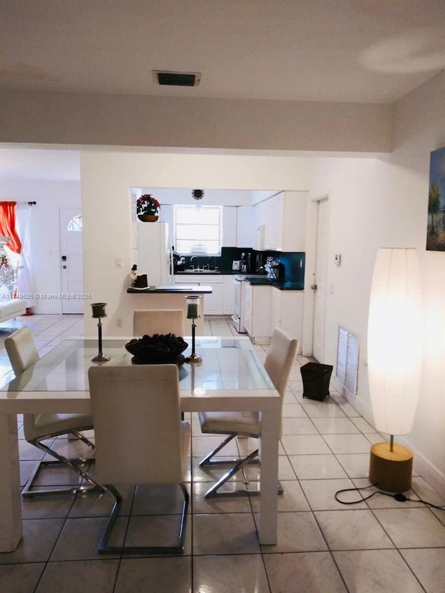 dining space with visible vents, baseboards, and light tile patterned floors