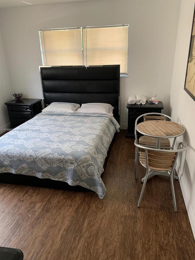 bedroom featuring dark wood-style floors and baseboards