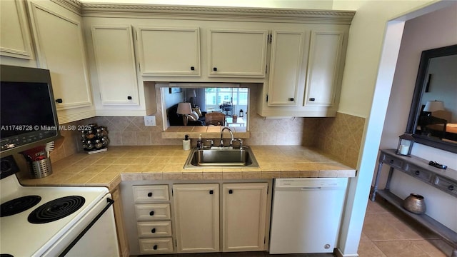 kitchen featuring white appliances, tasteful backsplash, tile counters, cream cabinetry, and a sink