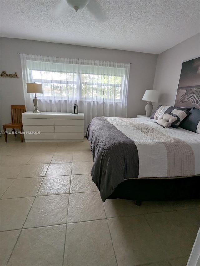 bedroom with light tile patterned floors and a textured ceiling