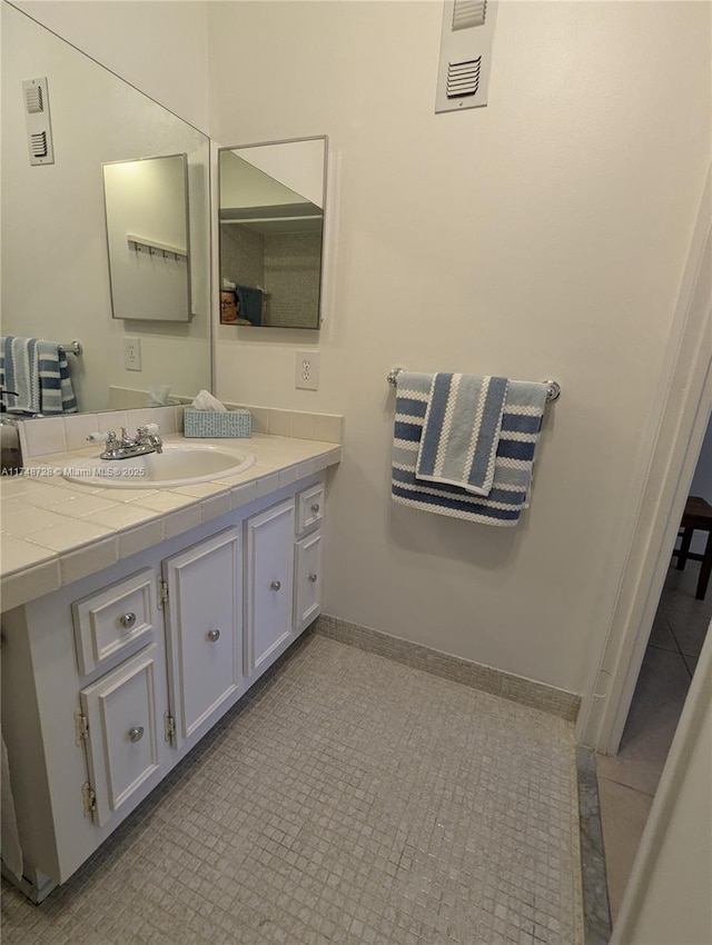 bathroom with baseboards, visible vents, and vanity