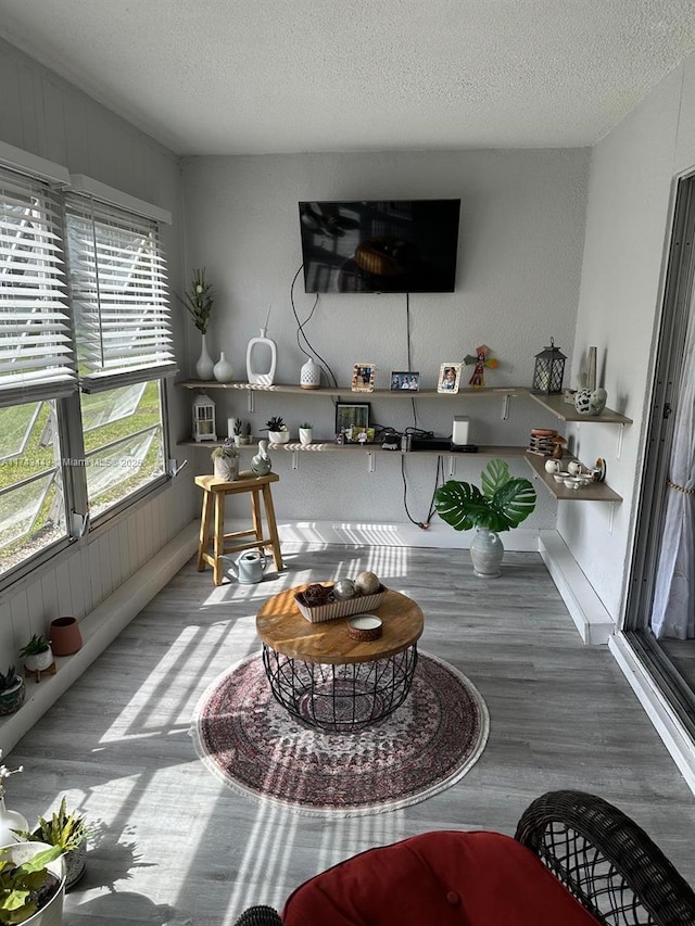 interior space with a textured ceiling and wood finished floors