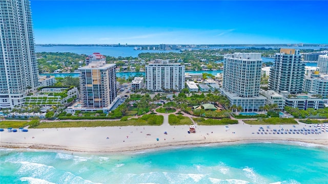 drone / aerial view featuring a beach view, a city view, and a water view