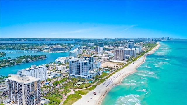 drone / aerial view with a beach view, a city view, and a water view
