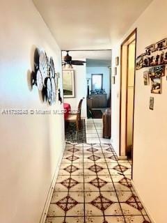 hallway featuring baseboards and light tile patterned floors