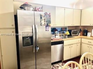 kitchen featuring stainless steel appliances, light countertops, and white cabinetry