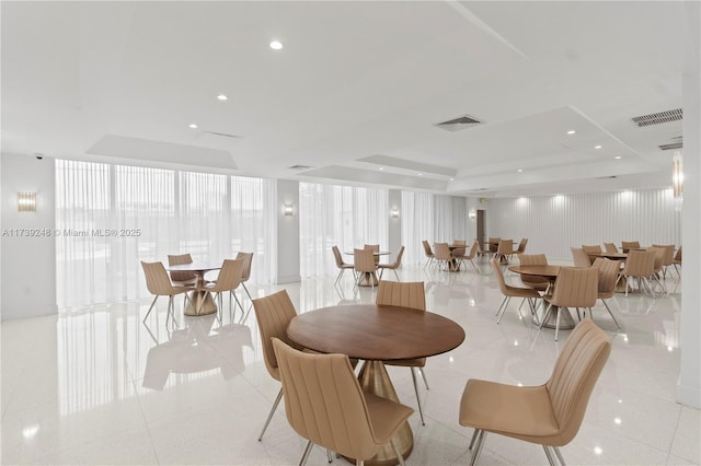 dining room with a raised ceiling, visible vents, and light tile patterned floors