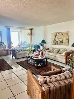 living area featuring tile patterned flooring and a textured ceiling