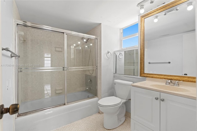 bathroom featuring vanity, toilet, tile patterned flooring, and bath / shower combo with glass door