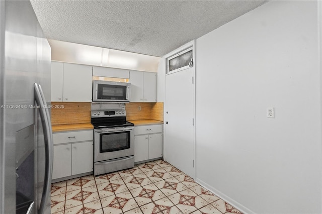 kitchen featuring light countertops, backsplash, a textured ceiling, and stainless steel appliances