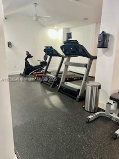 workout room with a ceiling fan and baseboards