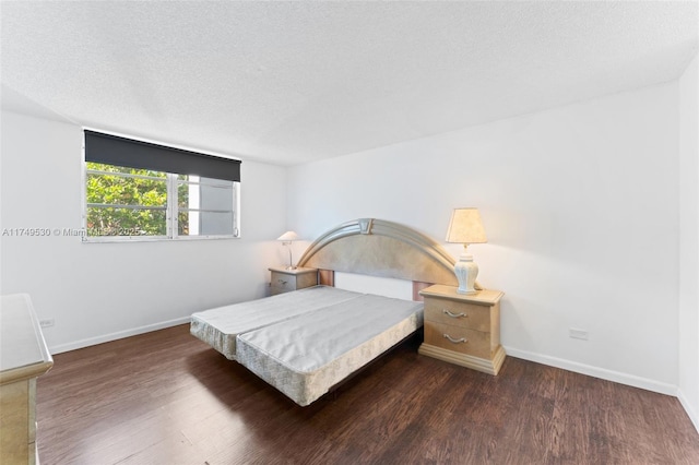 445 NE 195th St Unit 324, Miami, FL 33179 - bedroom with dark wood-style floors, a textured ceiling, and baseboards