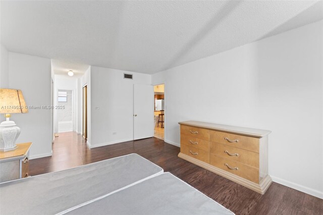 445 NE 195th St Unit 324, Miami, FL 33179 - bedroom with dark wood-style floors, a textured ceiling, visible vents, and baseboards
