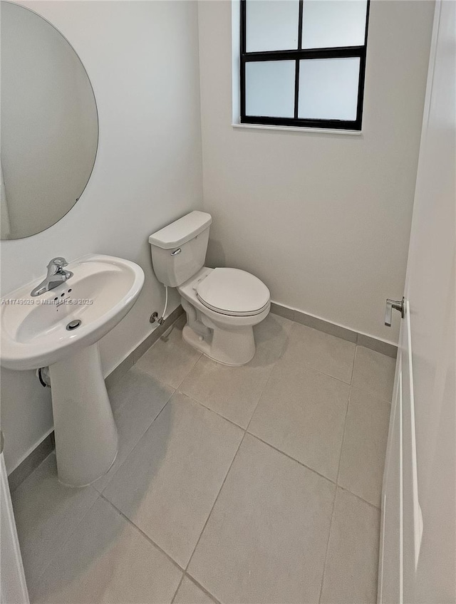 bathroom featuring toilet, baseboards, and tile patterned floors