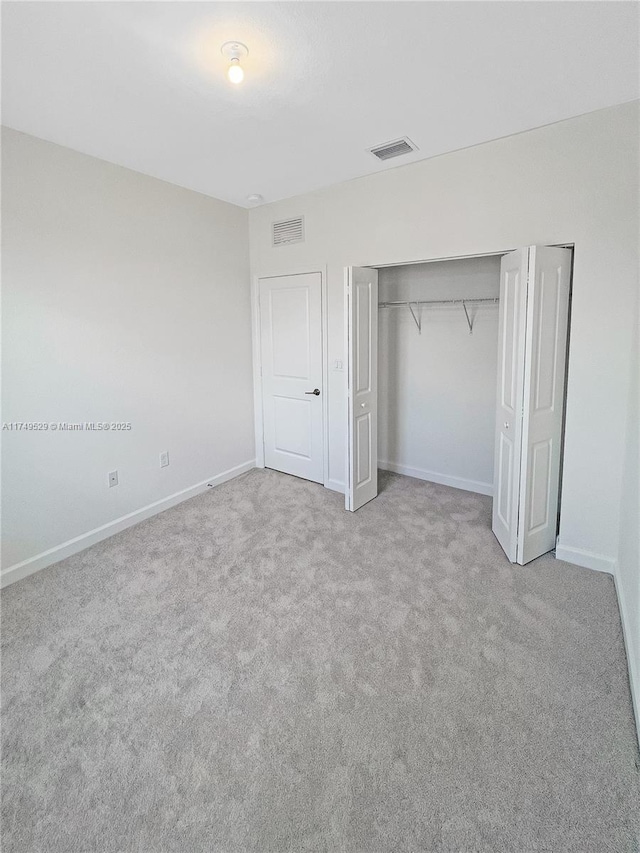 unfurnished bedroom featuring light colored carpet, visible vents, and baseboards