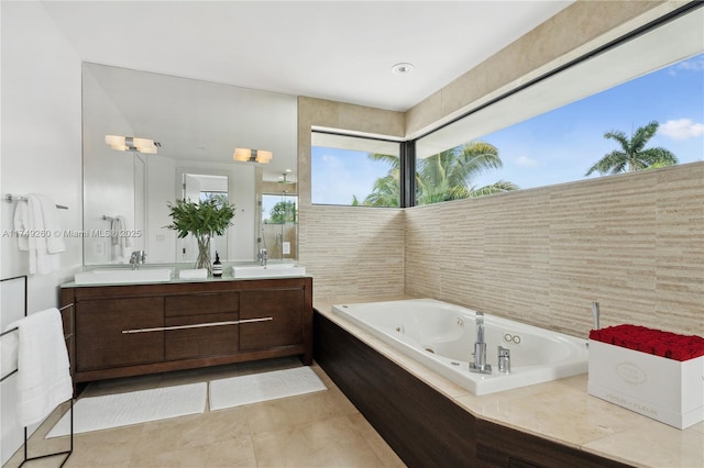 bathroom with double vanity, a jetted tub, a sink, and tile patterned floors