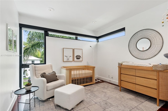 bedroom featuring a crib and baseboards