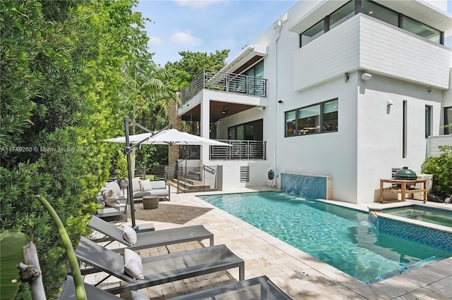 view of swimming pool with a patio area, a pool with connected hot tub, and an outdoor living space