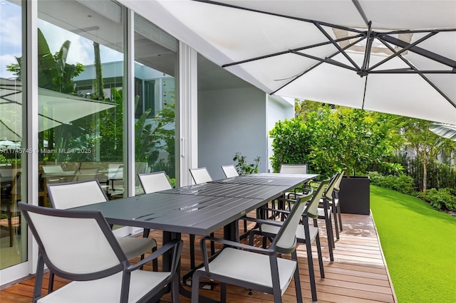 deck featuring outdoor dining space and a yard