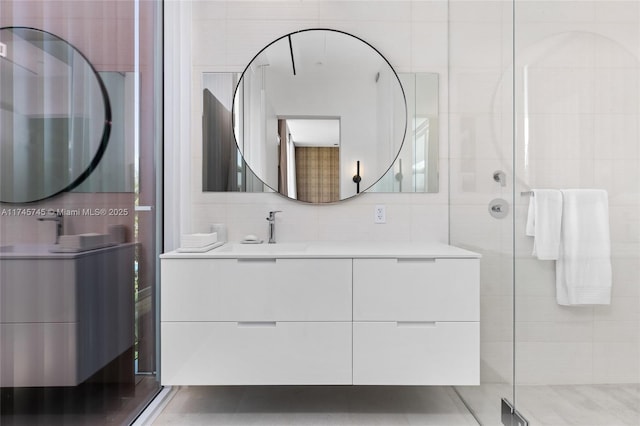 full bathroom featuring a stall shower, tile walls, backsplash, and vanity