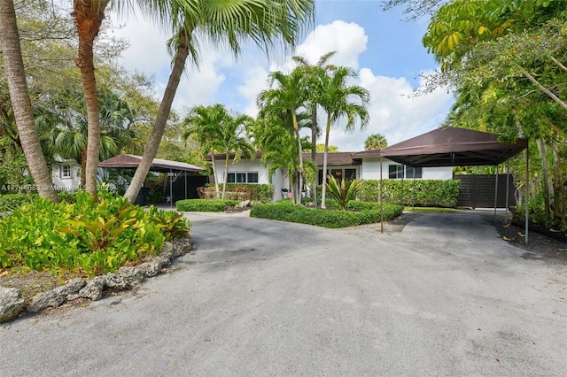 ranch-style house featuring aphalt driveway and a carport