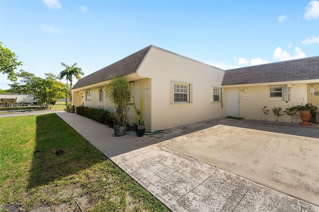 17084 SW 112th Ct Unit V3142, Miami, FL 33157 - view of property exterior featuring stucco siding, a shingled roof, a yard, and a patio area