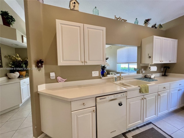 kitchen featuring light countertops, white cabinets, white dishwasher, a sink, and light tile patterned flooring