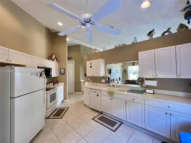 kitchen featuring white appliances, light countertops, a sink, and white cabinetry