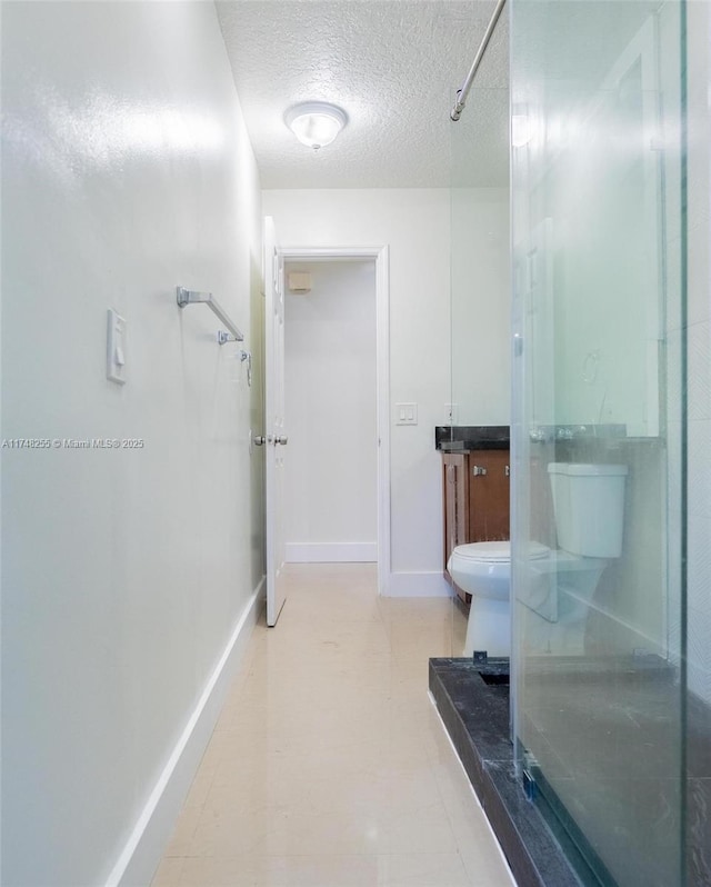 28451 SW 164th Ave, Homestead, FL 33033 - bathroom featuring a textured ceiling, a shower, vanity, toilet, and baseboards