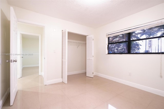 28451 SW 164th Ave, Homestead, FL 33033 - unfurnished bedroom featuring a closet, a textured ceiling, and baseboards