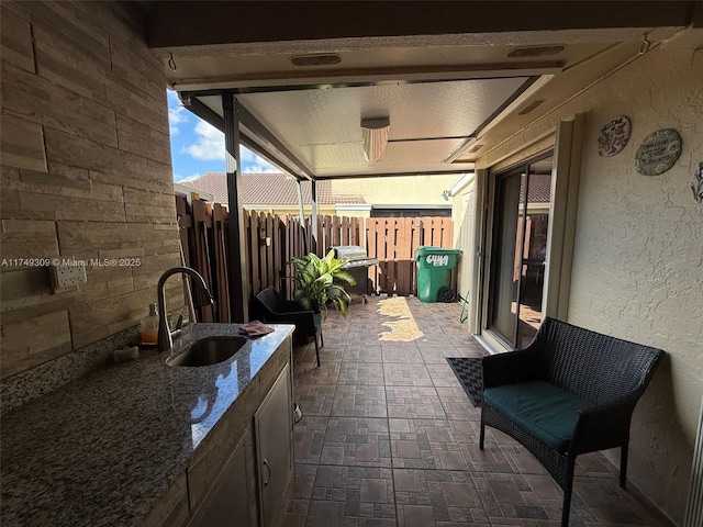 view of patio / terrace with area for grilling, a sink, and fence