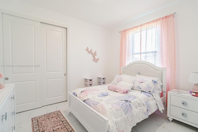 bedroom with marble finish floor and a closet