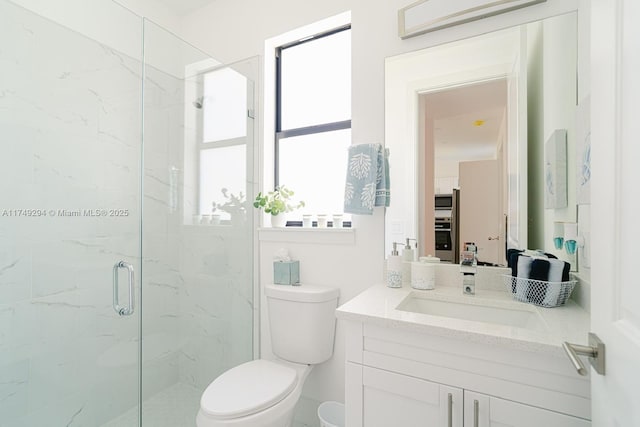 bathroom featuring vanity, a marble finish shower, and toilet