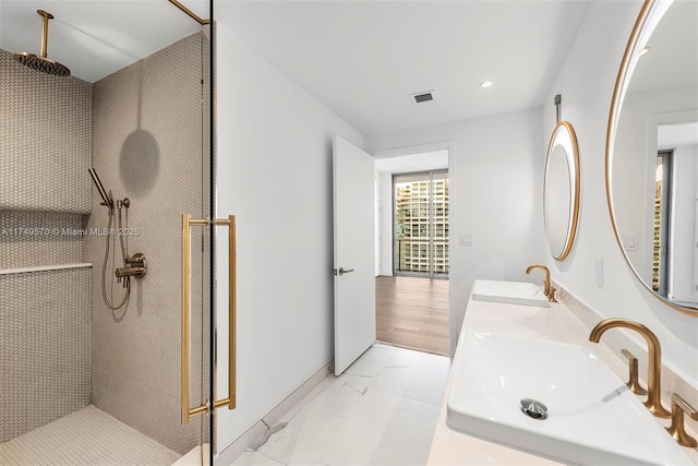 full bathroom with recessed lighting, marble finish floor, a sink, and a shower stall