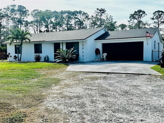 single story home with a garage, a front lawn, concrete driveway, and stucco siding